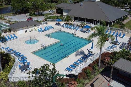 an overhead view of a large swimming pool with blue chairs at 4111 Gunnison Ct #1214 in Estero