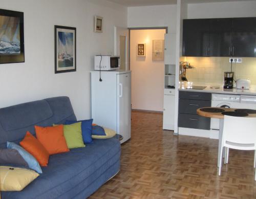 un soggiorno con divano blu e una cucina di T2-300m plage-L'Estacade- St enogat à Dinard a Dinard