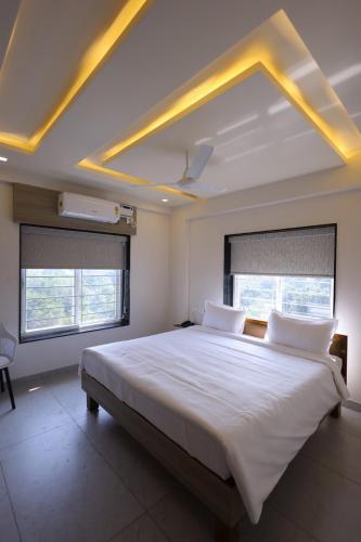 a bedroom with a large bed with white sheets at Hotel Rock Port Inn in Rushikonda