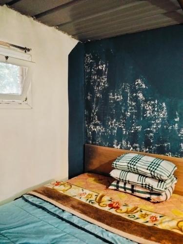 a bed in a room with a blue wall at le Cabanon Beldi in Rabat