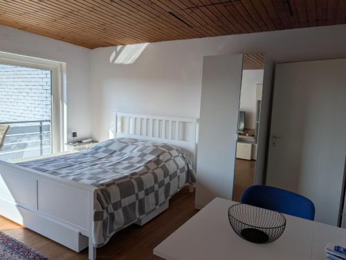 a bedroom with a bed and a table and a window at Helles, sonniges, ruhiges Apartment in Wuppertal