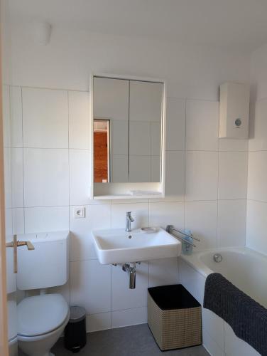 a white bathroom with a sink and a toilet at Helles, sonniges, ruhiges Apartment in Wuppertal