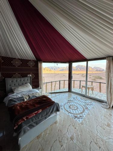 a bed in a tent with a view of the desert at Star City Camp wadirum in Wadi Rum