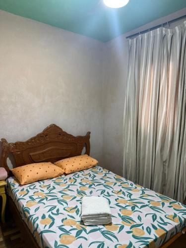 a bedroom with a bed with a bedspread and a window at Alanna temporada in Olímpia