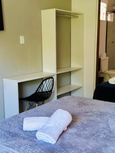 a bedroom with a bed with a towel on it at Pousada Jardins in São Luís