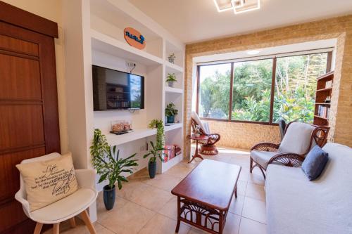 a living room with a couch and a tv at Piale Palms Makenzie Beach Front Apartment Larnaca Airport Area in Larnaca