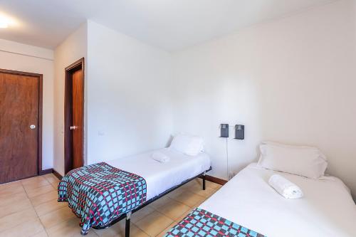 a room with two beds and a door at HI Guarda - Pousada de Juventude in Guarda