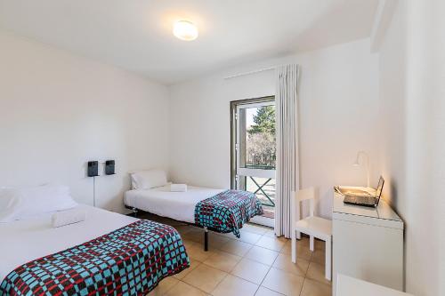 a bedroom with two beds and a window at HI Guarda - Pousada de Juventude in Guarda