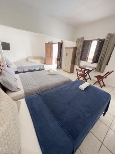 a room with two beds and a couch and windows at Pousada Jardins in São Luís
