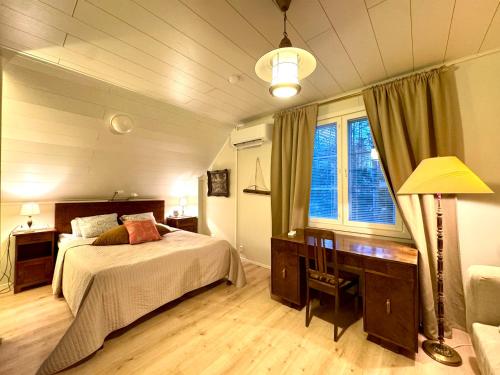 a bedroom with a bed and a desk and a window at Villa Santala in Naantali