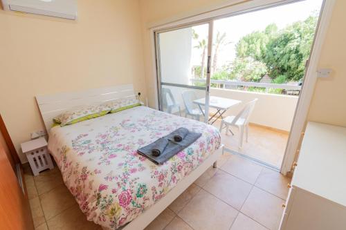 a bedroom with a bed and a balcony at Piale Palms Makenzie Beach Front Apartment Larnaca Airport Area in Larnaca