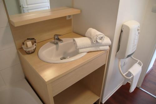 a bathroom with a sink and a soap dispenser at Oly Vacances Les Landes in Cassen