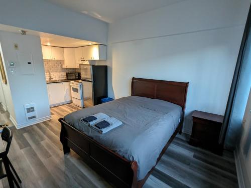 a small bedroom with a bed and a kitchen at Les appartements HOMA in Montréal