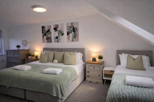 a bedroom with two beds with green blankets at York Boutique House- spacious & stylish with free parking in York