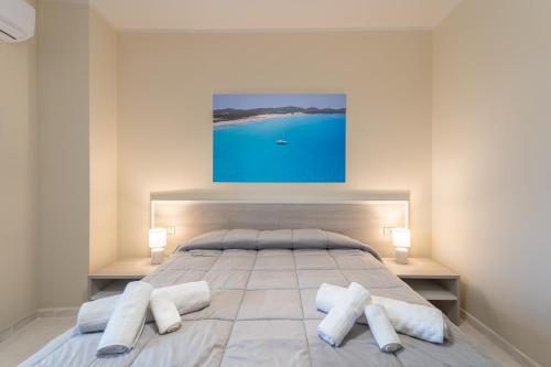 a bedroom with a large bed with two pillows at Via del Mare in Giba