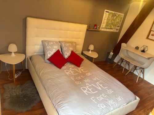 a bed with red pillows and a sink in a room at Chambre Serres Ponçon in Savines