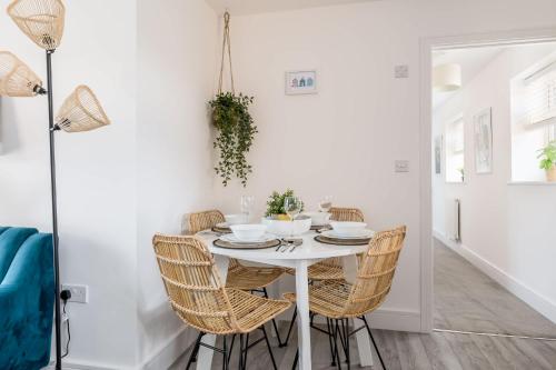 a white dining room with a white table and chairs at Seas the Day - Moments from Hamworthy Beach and Park in Poole