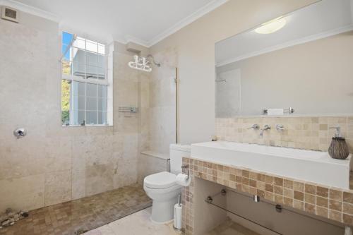 a bathroom with a tub and a toilet and a sink at White Waters in Cape Town