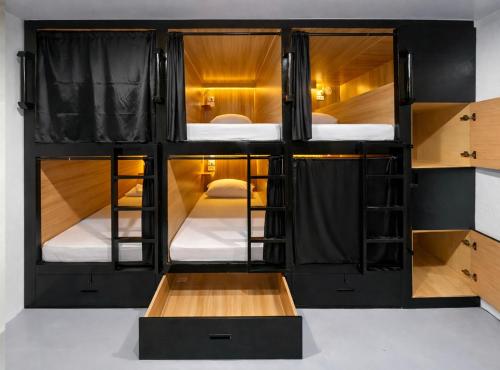 a room with four bunk beds and a table at Islanders Hostel Siquijor in San Juan