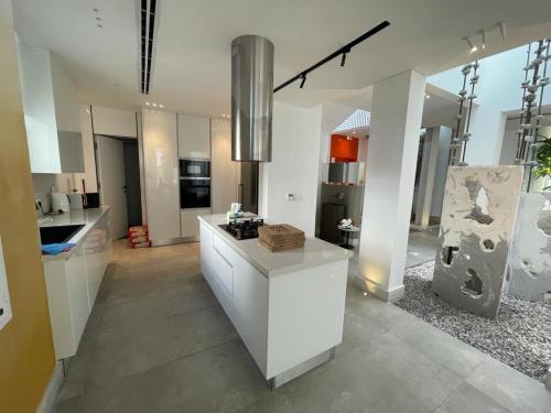 a large kitchen with white cabinets and a counter at Seashell 2nd row sea Villa in El Alamein
