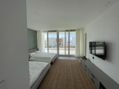a bedroom with two beds and a flat screen tv at Seashell 2nd row sea Villa in El Alamein