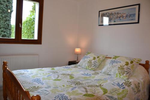a bed with a blanket and pillows on it at L'ESCALE SINAGOTE Gîte in Séné