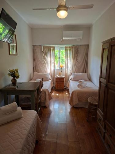 a bedroom with two beds and a table and a desk at Hotel El Descanso in Junín