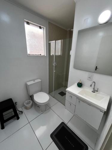 a white bathroom with a toilet and a sink at Apartamento de 3 Quartos com Ar Condicionado in Piracicaba