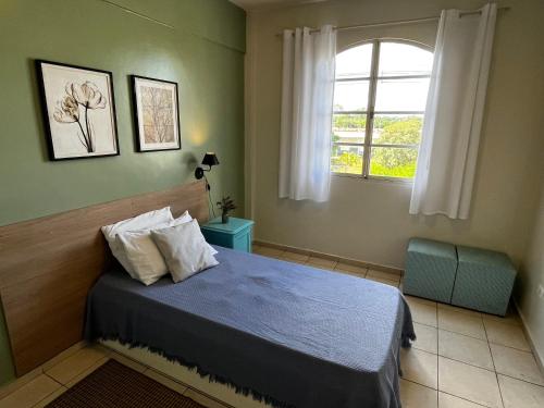 a bedroom with a blue bed and a window at Apartamento de 3 Quartos com Ar Condicionado in Piracicaba
