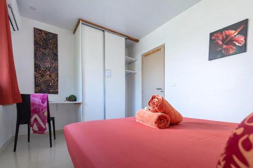 a bedroom with a bed with a red blanket at Moorea bungalow cosy proche plage de Temae in Moorea