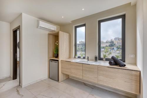 a bathroom with a sink and a window at 6BR luxury villa with Pool & Hot tub - 2Living rooms & 10Bathrooms in Tal-Għoqod