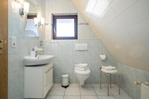 a white bathroom with a sink and a toilet at Ferienwohnung mit Balkon in Rechlin