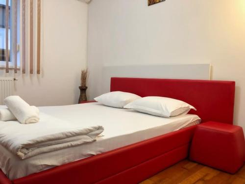 a red bed with white pillows and a red headboard at Joy City Stay Calea Timisoarei 4 in Timişoara