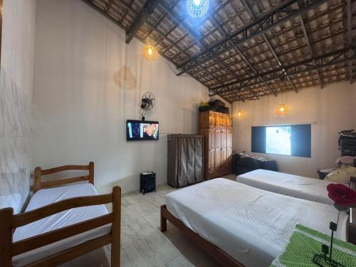 a bedroom with two beds and a flat screen tv at Chácara Conquistando II in Jarinu