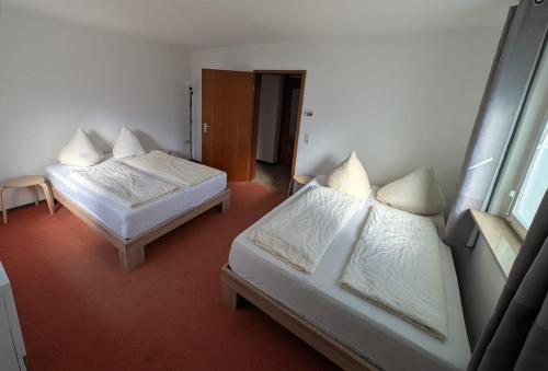 two beds in a room with white sheets and pillows at Easy Stay Valencia in Oberboihingen