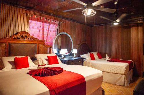 a bedroom with two beds with a mirror and a fan at Master Universel Hotel Bar Restaurant in Cap-Haïtien