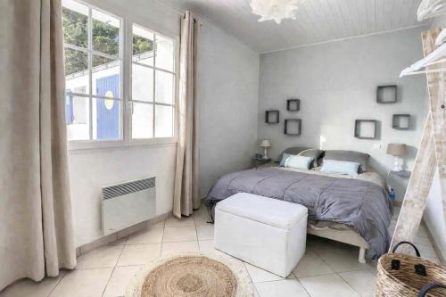 a bedroom with a bed and a large window at L'écrin des Ormeaux - sur l'île - 300 m de la plage in Barbâtre