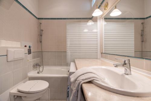 a bathroom with a sink and a toilet and a tub at Madach City Studio in Budapest