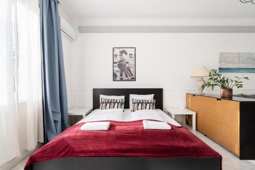a bedroom with a large bed with a red blanket at Madach City Studio in Budapest