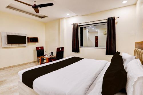 a bedroom with a large bed and a television at Townhouse OAK The Hotel Square Villa in Ghaziabad