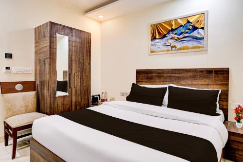 a bedroom with a large bed with a wooden headboard at Townhouse OAK The Hotel Square Villa in Ghaziabad