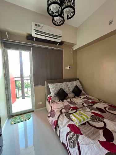 a bedroom with a bed and a window with a air conditioner at KEY REALTY SERVICES Ph in Pajak