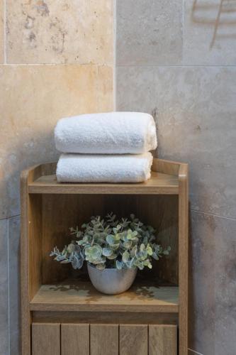 a wooden shelf with towels and a potted plant at Luss Cottages at Glenview in Luss