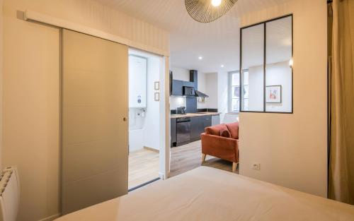 a bedroom with a sliding door to a living room at Le Choeur in Rodez