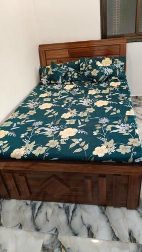 a bedroom with a bed with a blue and white floral bedspread at Rmeshwar homestay in Malvan