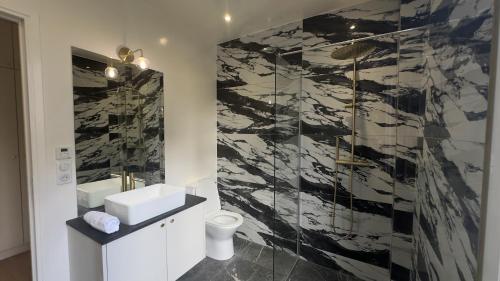 a bathroom with a black and white marble wall at Alma Hotel in Courbevoie