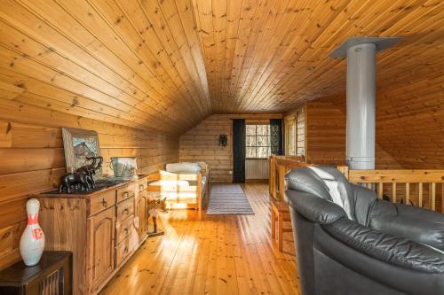 a living room with a leather couch in a log cabin at Ösjan 12 - Bruksvallarna in Bruksvallarna