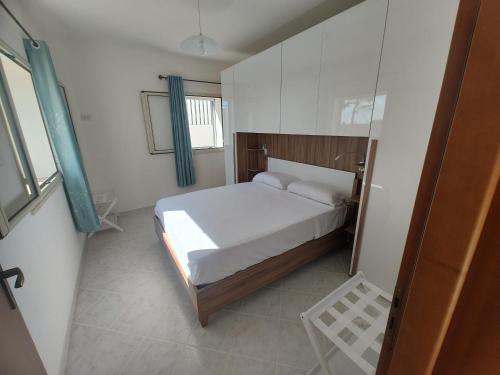 a small bedroom with a bed and a window at villa ingrassia in Favignana