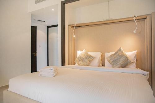 a bedroom with a large white bed with towels on it at Spacious 1 bedroom Apartment with Breathtaking Pool and Beach Views in Ras al Khaimah
