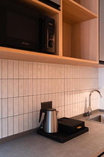 a kitchen counter with a tea kettle on a stove at Alt Life Stays - Manyata Tech Park in Bangalore